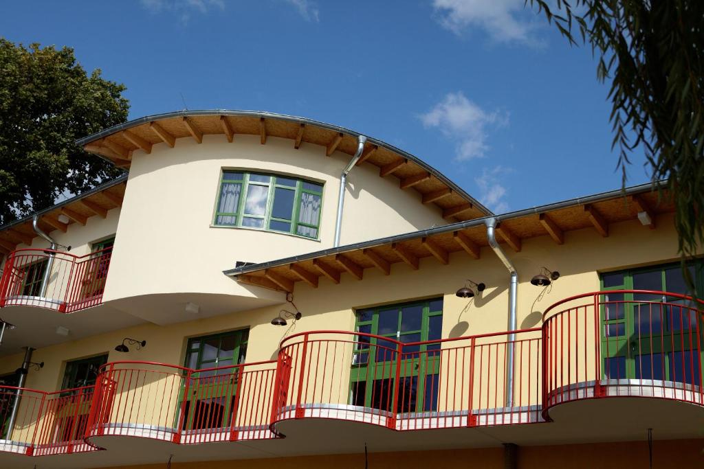 柏林森米纳 - 弗拉斯巴德加藤斯特拉斯旅馆的一座设有红色阳台和蓝天的建筑