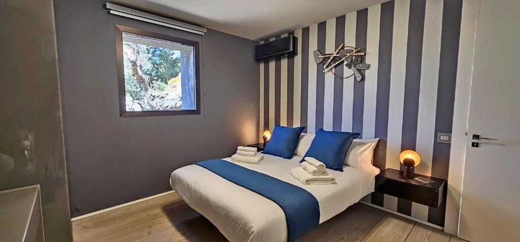 卡塔尼亚Rahal - Luxury house with pool - A perferfect getaway的一间卧室配有一张带蓝色枕头的床和一扇窗户。