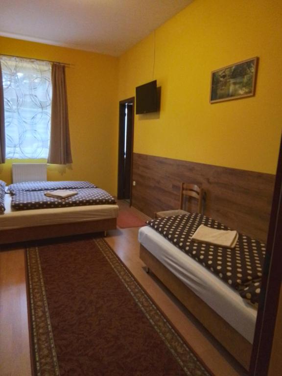 CsákánydoroszlóÖrségkapuja Vendégház的黄色墙壁客房的两张床