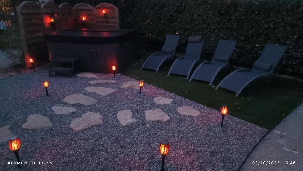 谢瓦布朗克La Remise de Guytou et Spa的地面上一组椅子和蜡烛,灯光照亮