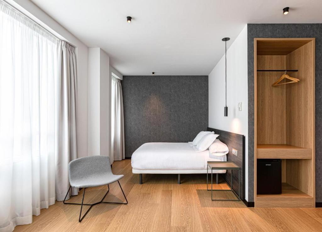 卢戈Hotel Forum Ceao的一间卧室配有一张床、一张桌子和一把椅子
