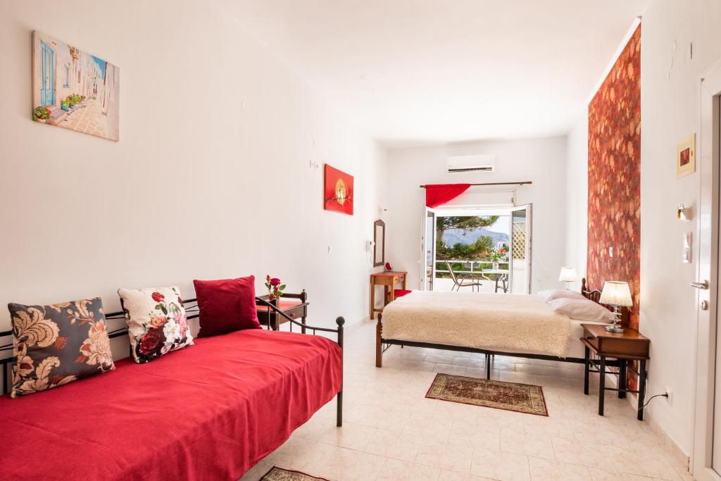 阿莫皮Perama Hotel, Karpathos的客厅配有红色的沙发和床。