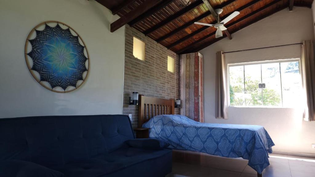 布埃诺布兰当Chalés Recanto das Flores的客厅设有蓝色的沙发和窗户。
