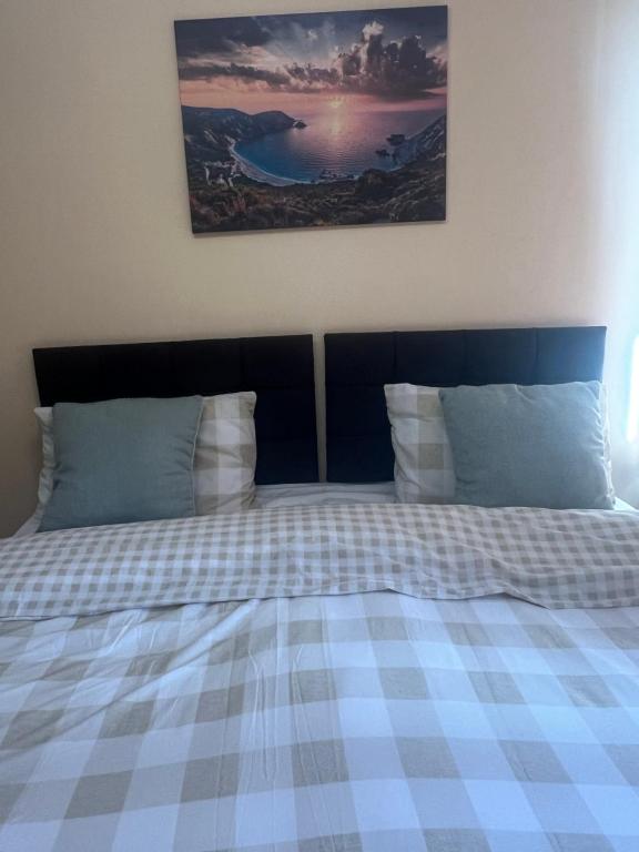 PitseaRoom in Essex的一张带 ⁇ 子毯子和枕头的床