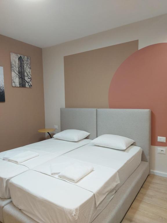 地拉那Center Cozy Nest的一间卧室配有一张带白色床单的大床