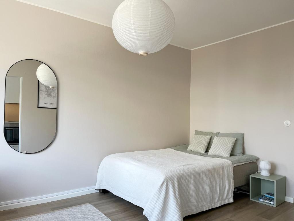 埃斯波Garden city studio的一间卧室配有一张床和镜子