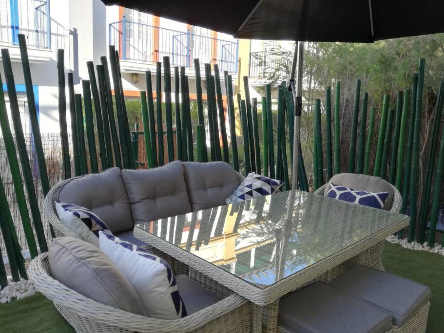 Praia VerdeCasa Bambu, Paraiso na Terra的玻璃桌子和椅子及雨伞