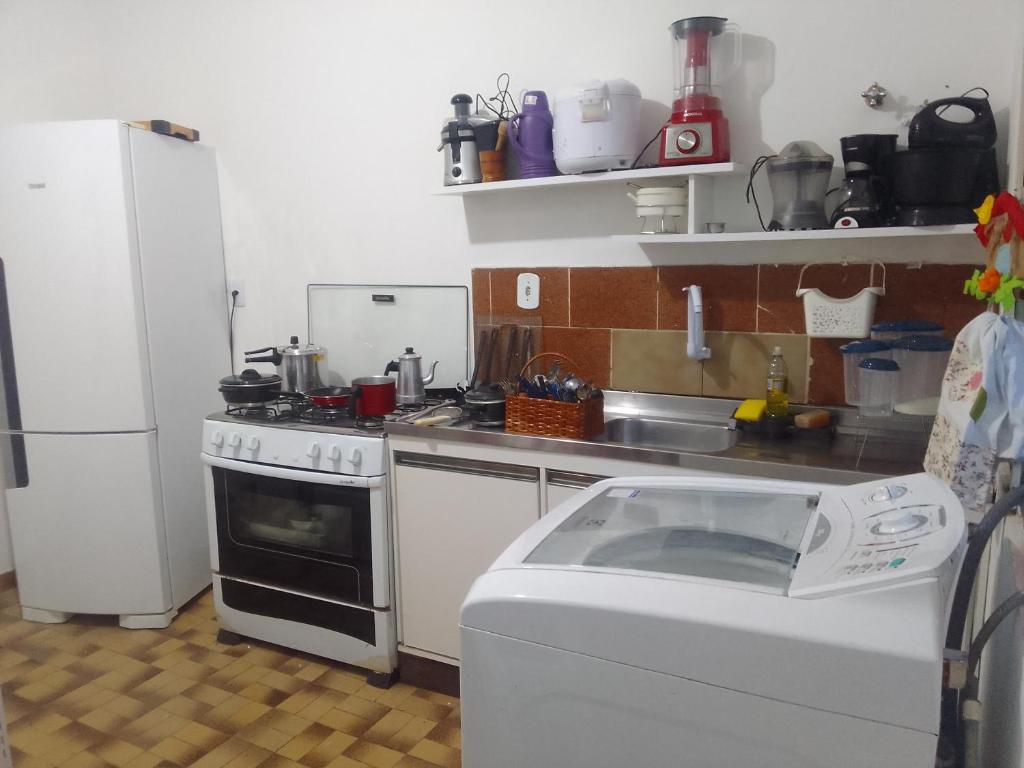 科伦巴LINDO APTO CENTRAL, MOBILIADO, AO LADO DO HOTEL NACIONAL CORUMBÁ -MS的厨房配有炉灶和冰箱。