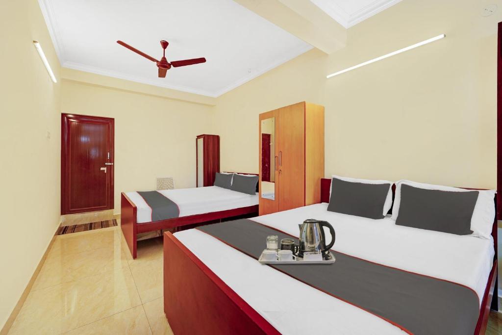 钦奈Collection O Arn Guest House Near Chennai International Airport的一间卧室配有两张床和吊扇