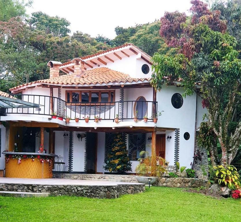 MéridaVilla Valcore的带阳台和庭院的白色房屋