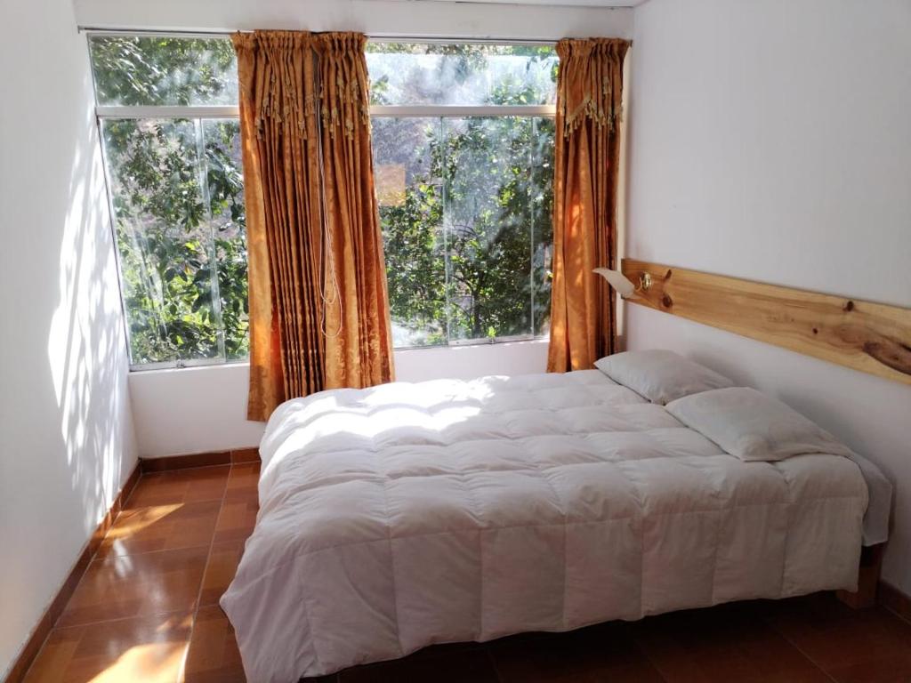 卡瓦纳科德Eden Lodge的一间卧室设有一张大床和两个窗户。