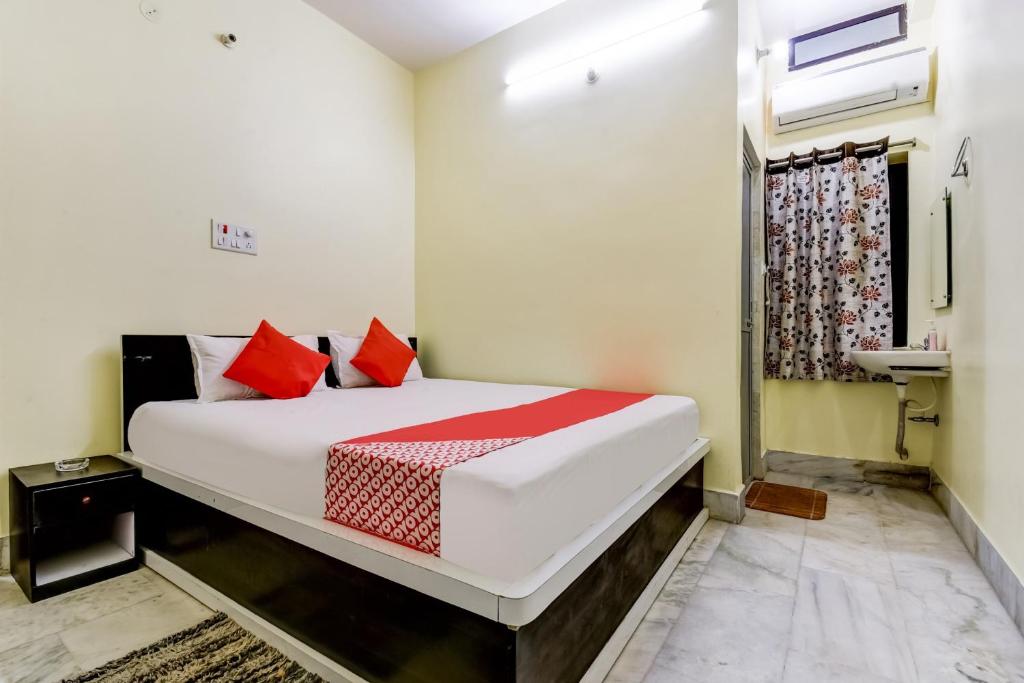 BankipurHotel Basera的卧室配有带红色枕头的大型白色床