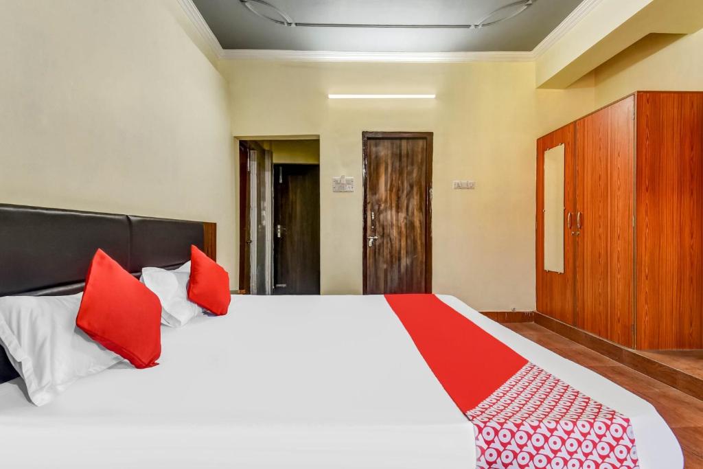 巴特那Super OYO Olive Grand的卧室配有带红色枕头的大型白色床