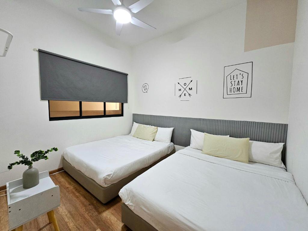 马六甲Quartz Paragon Suites By GGM的一间卧室配有两张床和一台平面电视