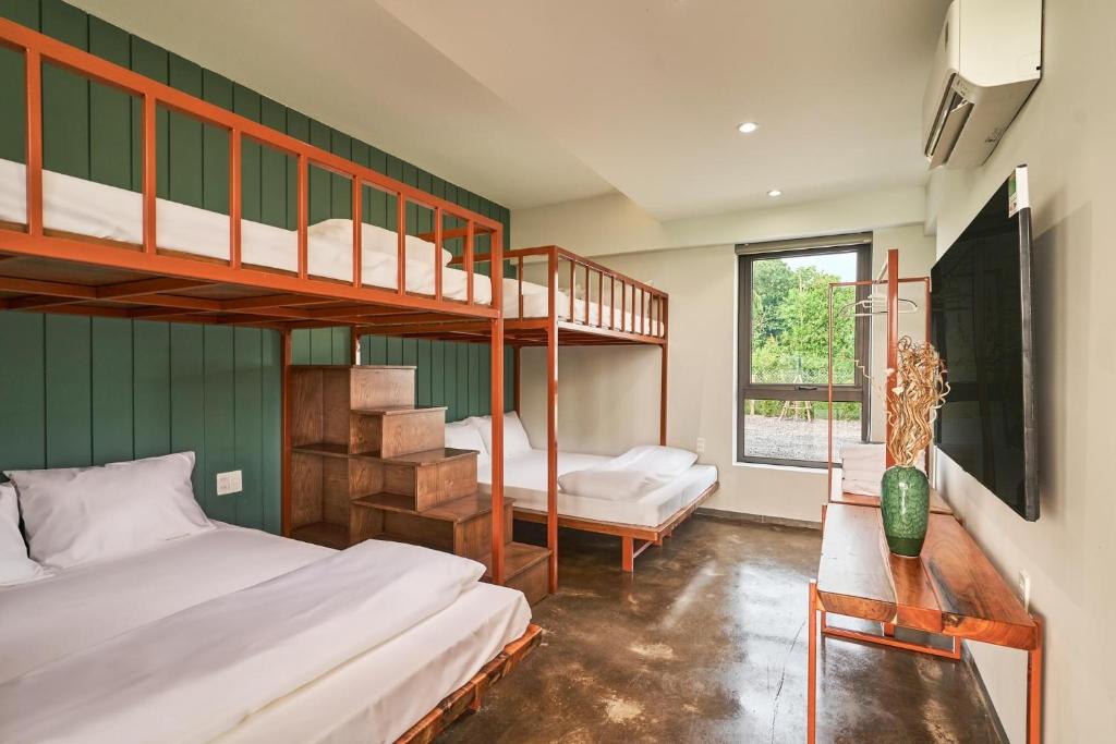 Ấp Bình YênBEAUCHAMP VILLA的一间卧室设有两张双层床和一扇窗户。