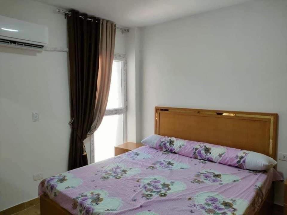 Al Ḩammādشاليهات مارينا دلتا ولاجونز的一间卧室配有一张带紫色棉被的床和窗户。