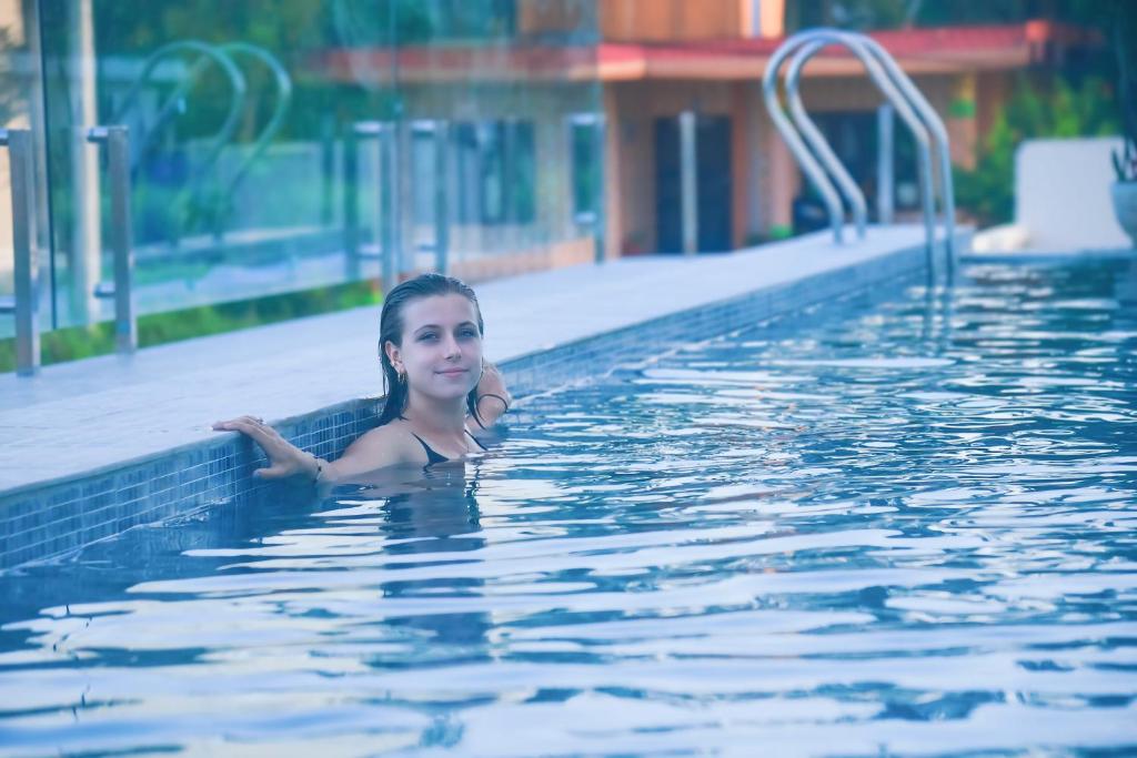 索拉哈Hotel Aikawa的年轻女子在游泳池游泳