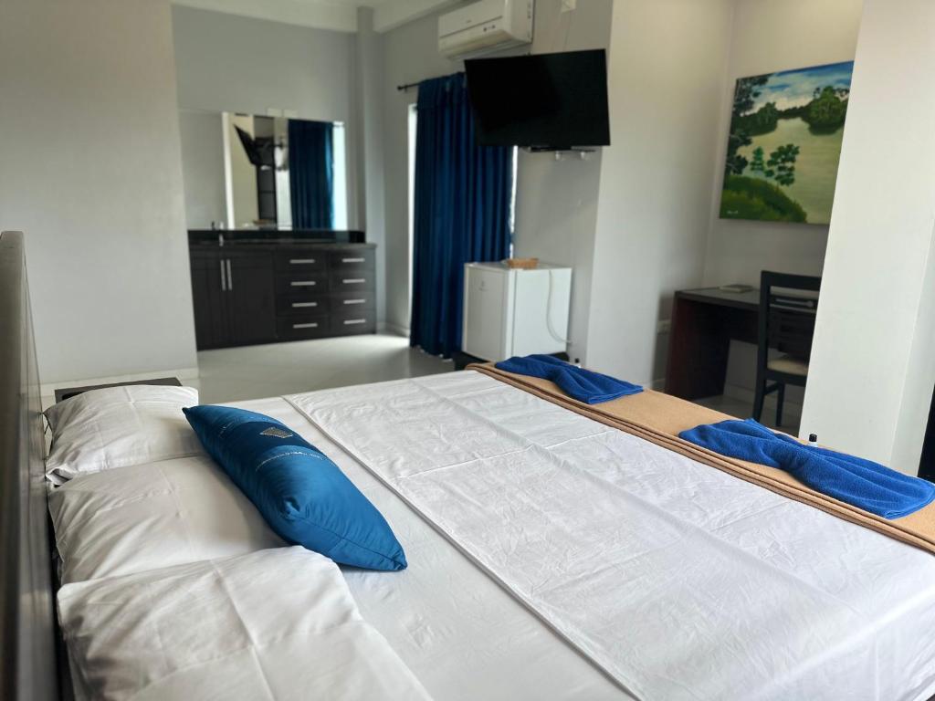 塔巴廷加Hotel Cristo rey的一张大白色的床,里面配有蓝色枕头