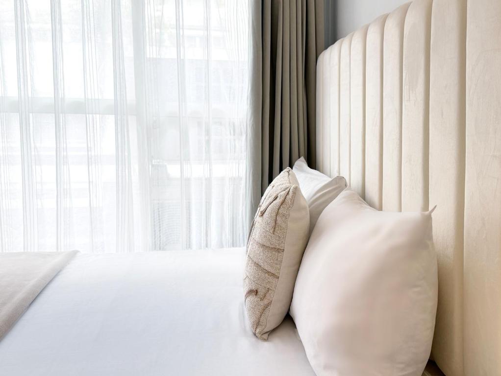 台北所在行旅-小所在 urban abode apartments的一间卧室配有带两个枕头的床和窗户