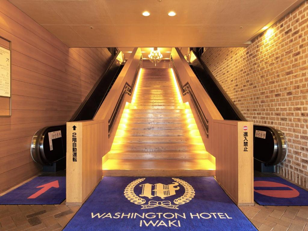 磐城磐城华盛顿酒店的建筑物内有标志的长自动扶梯