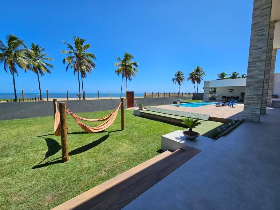 Barra do SirinhaémBeira mar com vista espetacular! Quinta da Barra!的后院设有吊床,享有海滩美景
