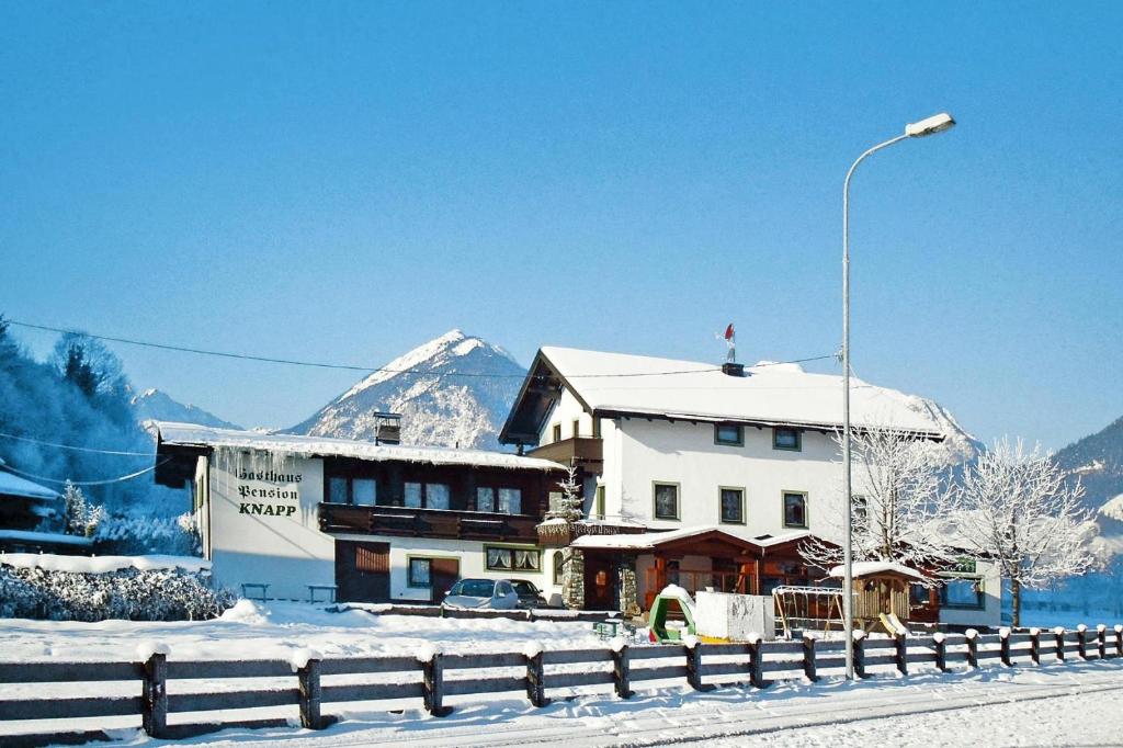 齐勒谷地施特拉斯Apartment in Strass im Zillertal in a beautiful setting的雪中的房子,背景是山