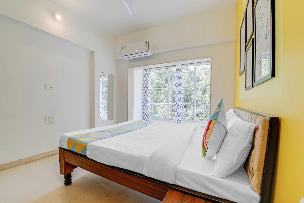 多纳保拉OYO Home Hotel Sea Prince Suites的一间卧室设有一张大床和窗户