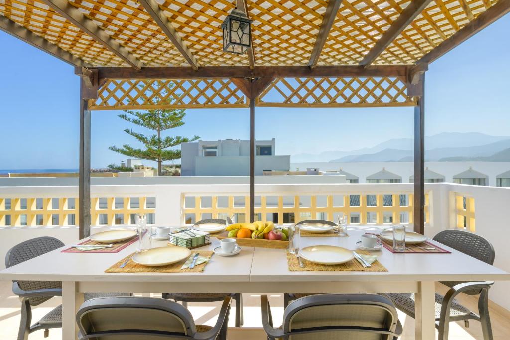 赫索尼索斯阿里斯一室公寓的阳台上配有白色桌椅