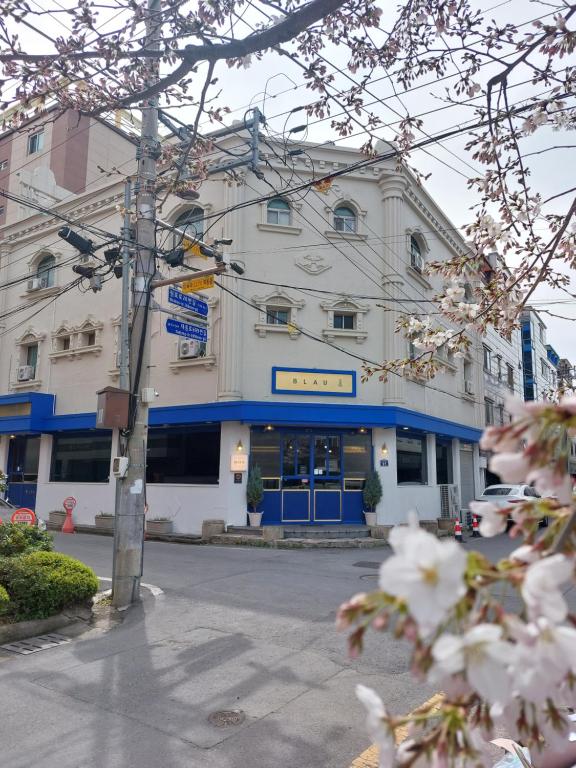 庆州Blau Guesthouse的一条白色的大建筑,在街上装饰着蓝色的饰物