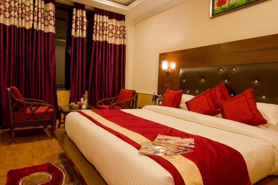 新德里Hotel HRS - New Delhi Railway Station的酒店客房配有一张带红色枕头的大床