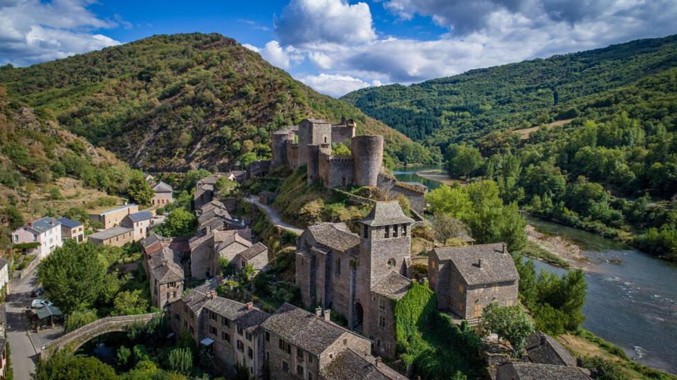 Brousse-le-ChâteauHôtel Restaurant Le Relays du Chasteau - Logis Hôtel的河畔山丘上的古老城堡