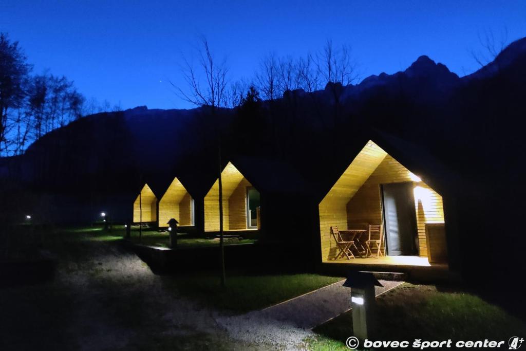 博维茨Base camp - Glamping resort Bovec的夜晚在田野里的一排小屋