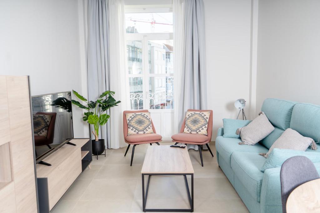 卡塔赫纳Apartamentos Turísticos Plaza del Rey的客厅配有蓝色的沙发和两把椅子