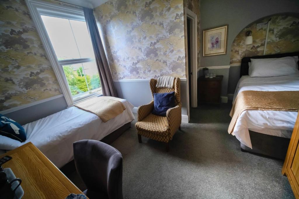 大莫尔文Cannara B and B的一间卧室设有两张床、一把椅子和一个窗户。