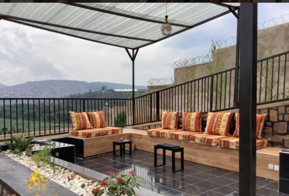 基加利Furnished House at Kibagabaga的一个带两张沙发和一张桌子的庭院和一个阳台