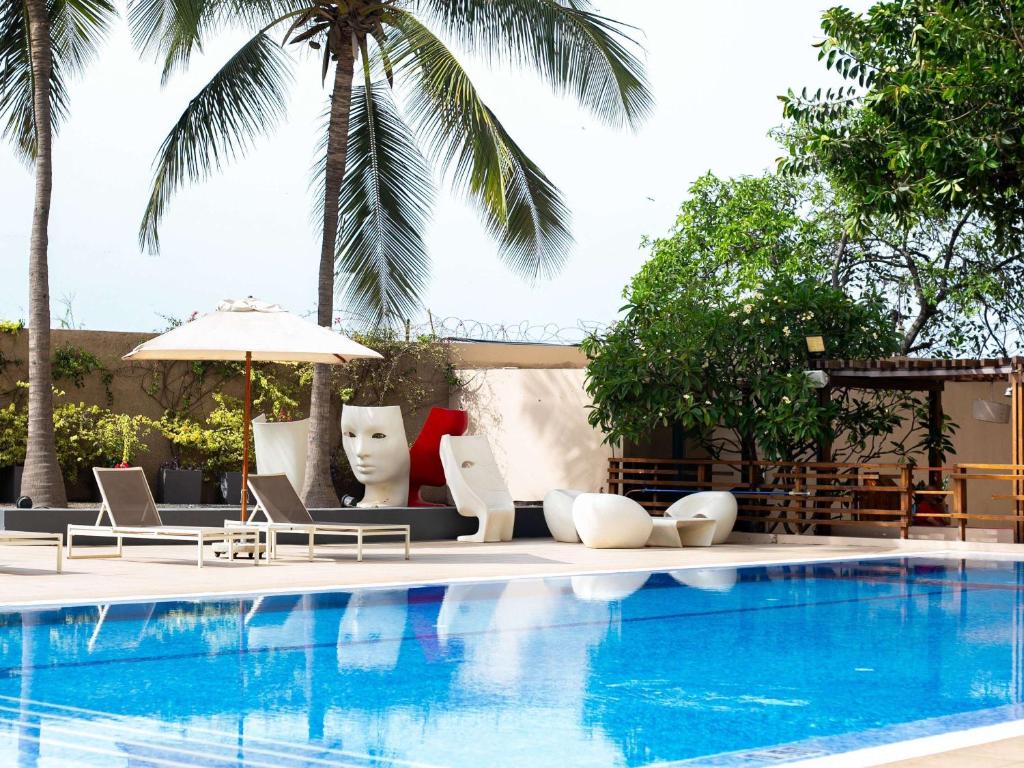 达喀尔诺富特达喀尔酒店的一个带躺椅的游泳池和一个游泳池