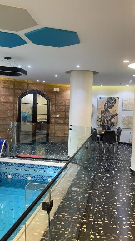 Al Ḩawīyahشقة مفروشة فاخرة的大楼内带桌椅的游泳池