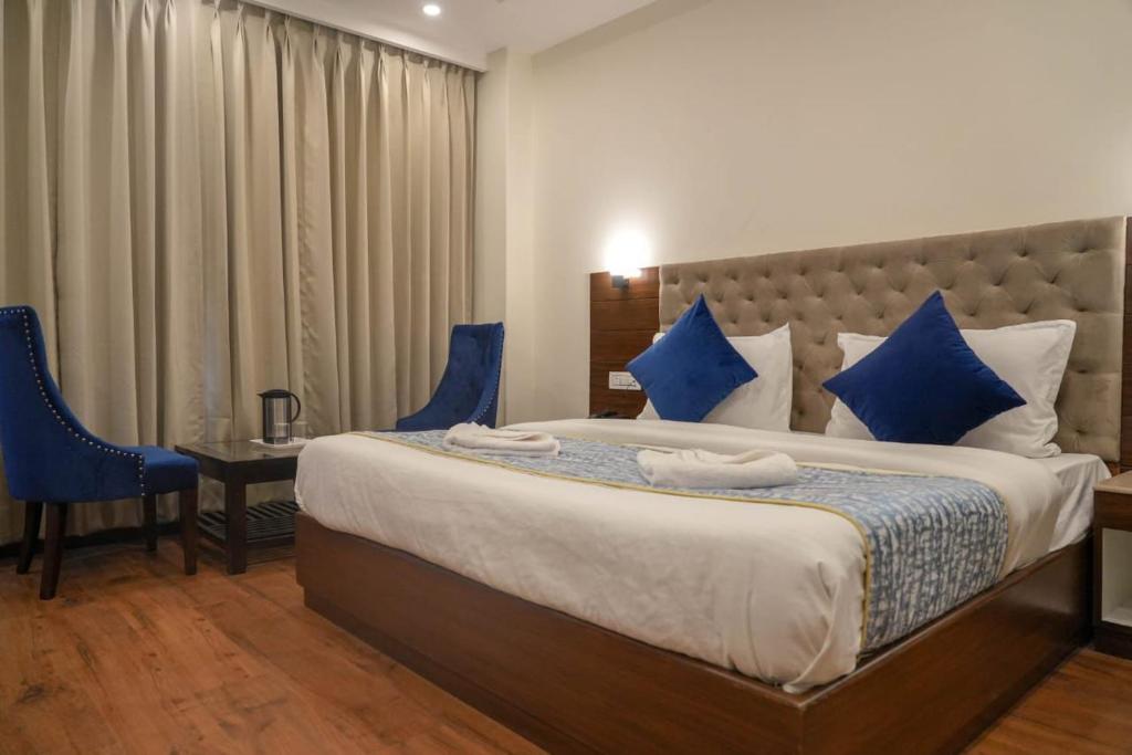 马拉里The Shivi Palace的一间卧室配有一张带蓝色枕头的大床