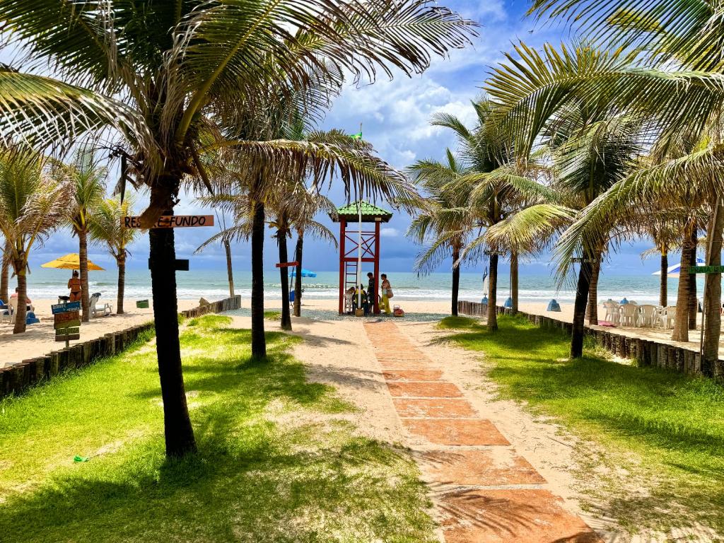 福塔莱萨Aquaville Resort的棕榈树海滩旁的步行道