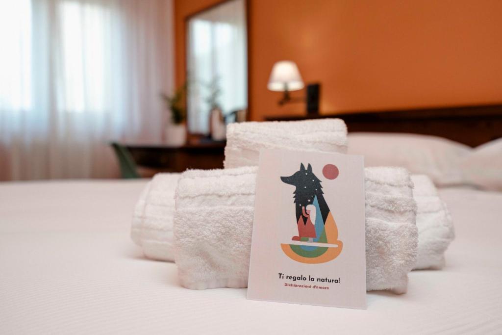 瓜尔迪亚格雷莱Hotel Altevie的床上有标志的一堆毛巾