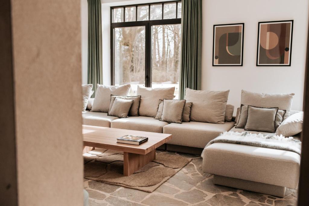 佐内贝克Vakantiewoning Domein Hooverbosch的客厅配有沙发和桌子