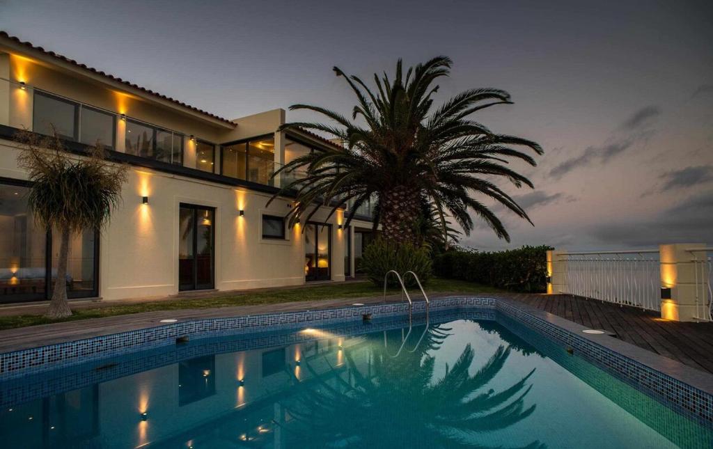 卡尼索Zula House - Stunning designer villa in spectacular location的房屋前有游泳池的房子
