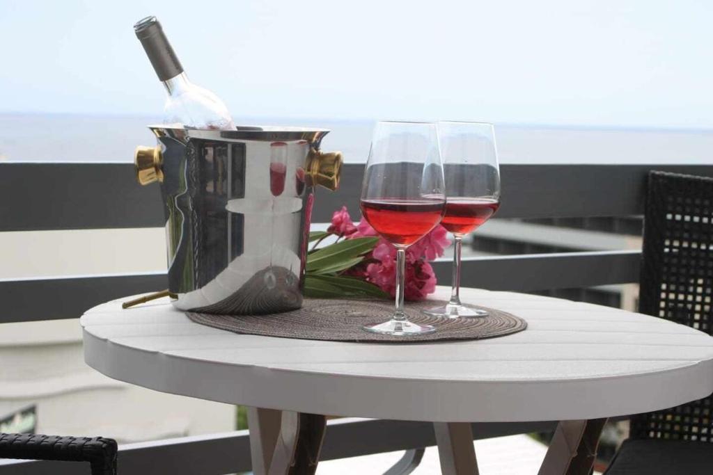 丰沙尔Lido Mar - Hotels area的一张桌子,上面放着两杯葡萄酒和一包钱包