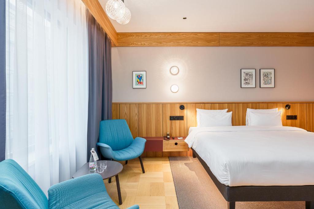 里加Aston Hotel Riga的酒店客房,配有一张床和一张蓝色椅子