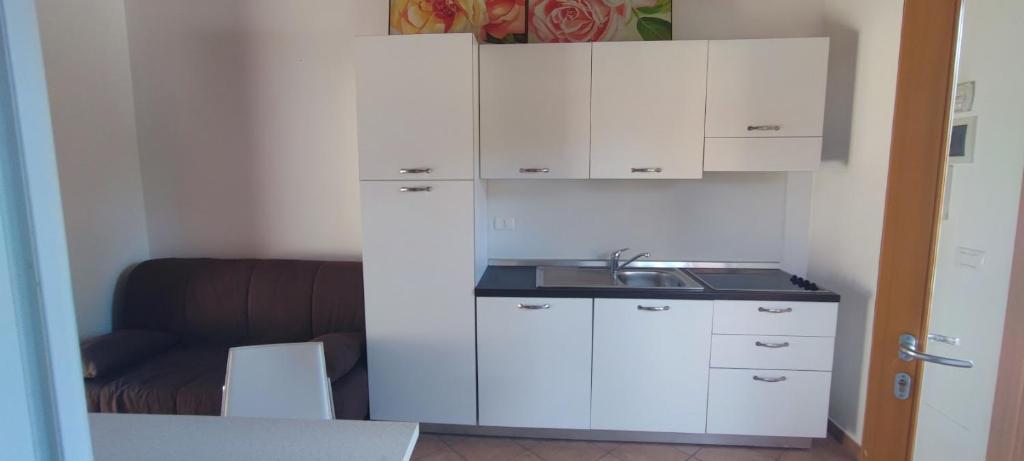玛里纳罗米亚Romea 2024的小厨房配有白色橱柜和水槽