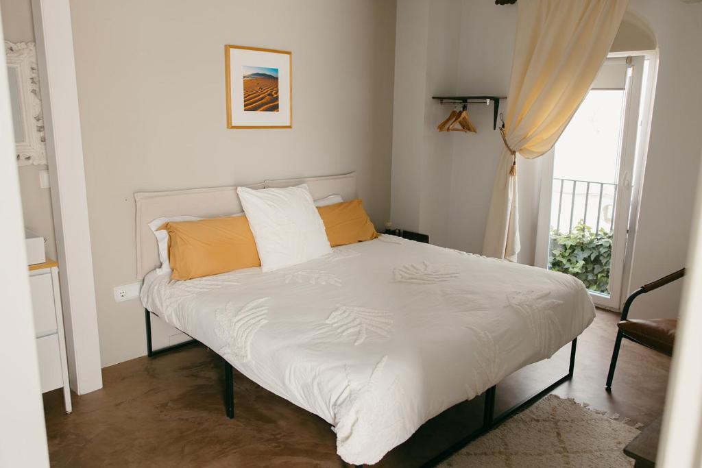 塔里法Casa Africa的卧室内的一张带白色床单和橙色枕头的床