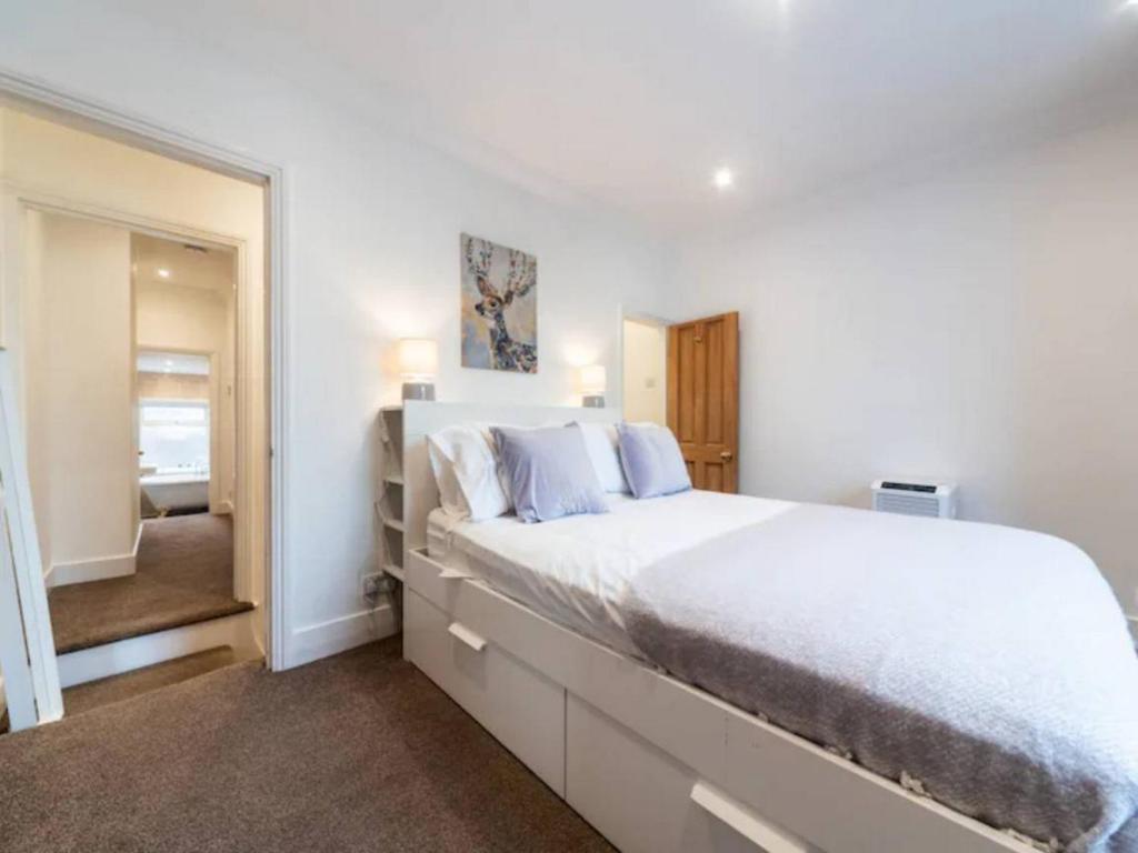 伦敦Charming Period Home near Surbiton with Garden的白色卧室设有一张大床和镜子