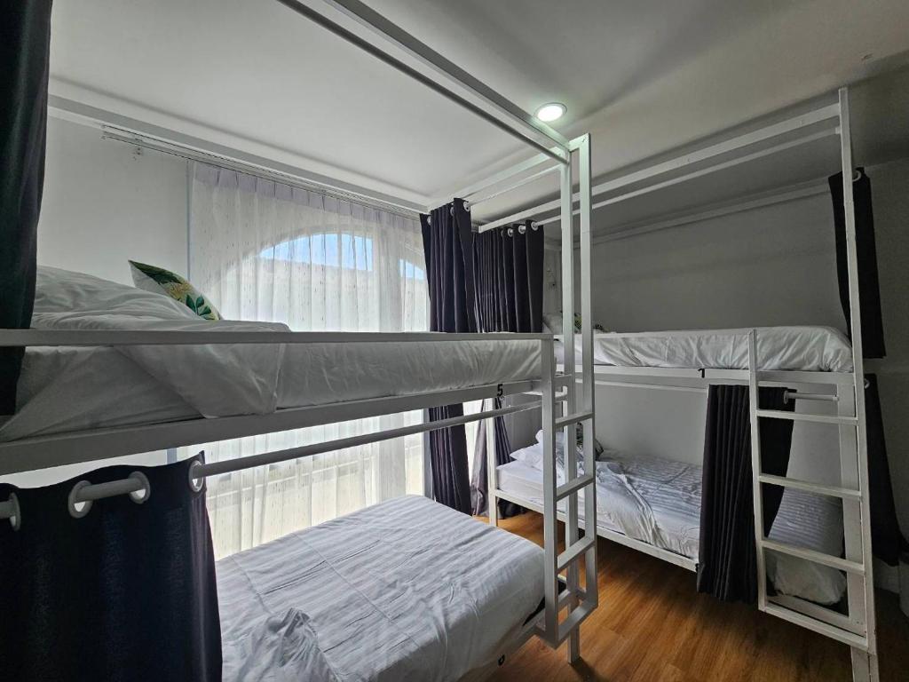 涛岛Tiger House Hostel Koh Tao的带窗户的客房内的两张双层床