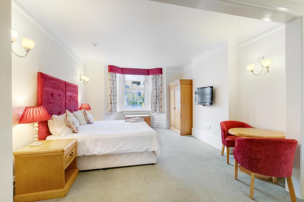 温莎Charles House - Windsor Castle的卧室配有一张床和一张桌子及椅子