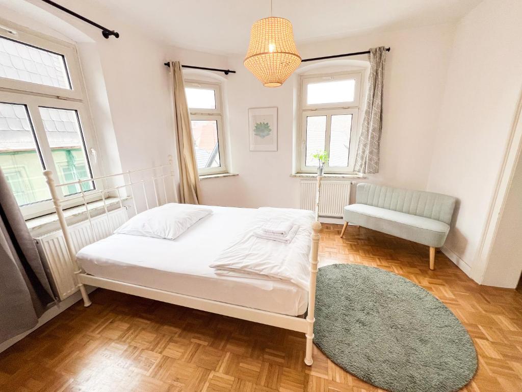 库姆巴赫Old Town Center Apartments的一间卧室配有一张床、一把椅子和窗户。